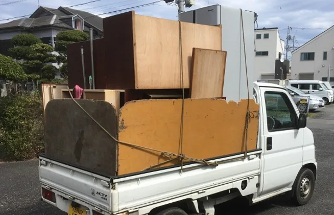 不用品を積んだ軽トラック
